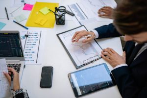 Team reviewing financial charts and digital data on tablets in an office setting. — A Guide to Canada's Best Online Cannabis