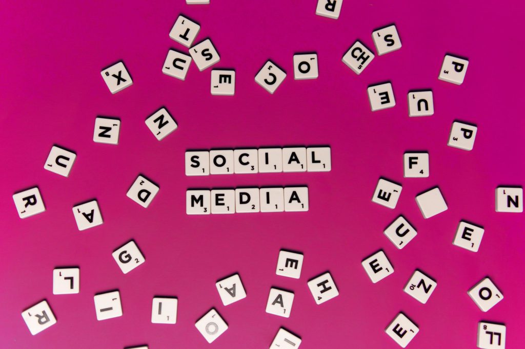 Alphabet tiles forming 'Social Media' on a vibrant pink background, perfect for digital marketing themes. — Accelerate Your I