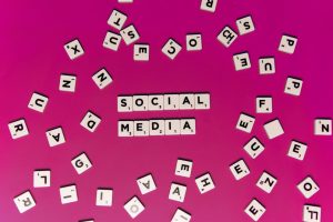 Alphabet tiles forming 'Social Media' on a vibrant pink background, perfect for digital marketing themes. — Accelerate Your I