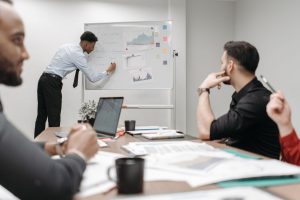 Colleagues in a business meeting discussing data and strategies at the office. — Age Verification Systems as a Tool for Prote