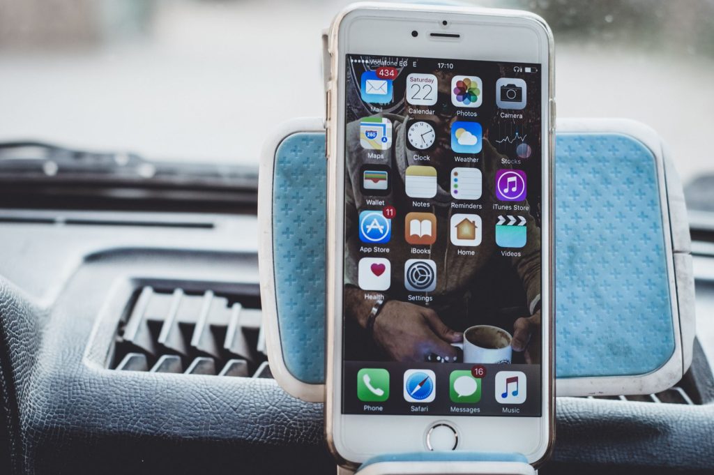 Close-up of a smartphone mounted on a car dashboard showing home screen with apps. — Biosphere Technology Basics