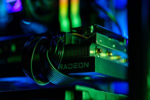 Detailed close-up of a gaming PC's Radeon graphics card with vibrant RGB lighting, showcasing cables and hardware. — Discover
