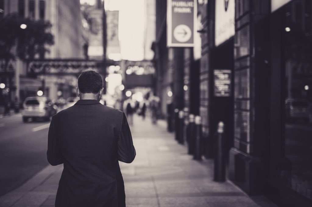 Man in a suit walking down a city street in a lonely, urban setting. — Enjoy the Benefits of On-Demand Relaxation with London