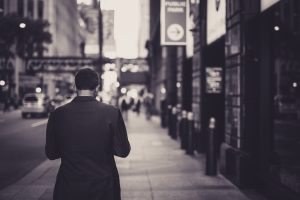 Man in a suit walking down a city street in a lonely, urban setting. — Enjoy the Benefits of On-Demand Relaxation with London
