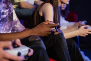 Teens playing video games with controllers, focused and engaged. — Equipment Needed to Start a Twitch Streaming Career