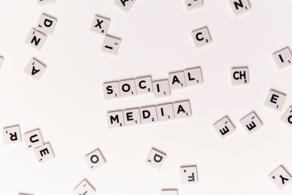 Flat lay of letter tiles spelling Social Media with scattered white tiles on a surface. — Facebook Like Details You Would Lik