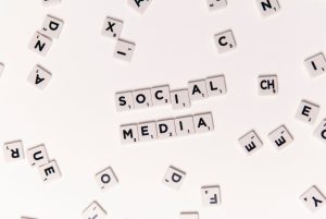 Flat lay of letter tiles spelling Social Media with scattered white tiles on a surface. — Facebook Like Details You Would Lik