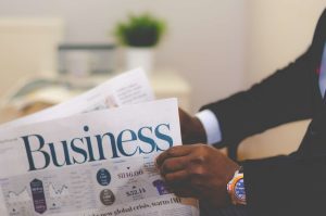 Close-up of a businessman reading a newspaper indoors, focusing on business headlines. — Five Clear Indicators That You're Re