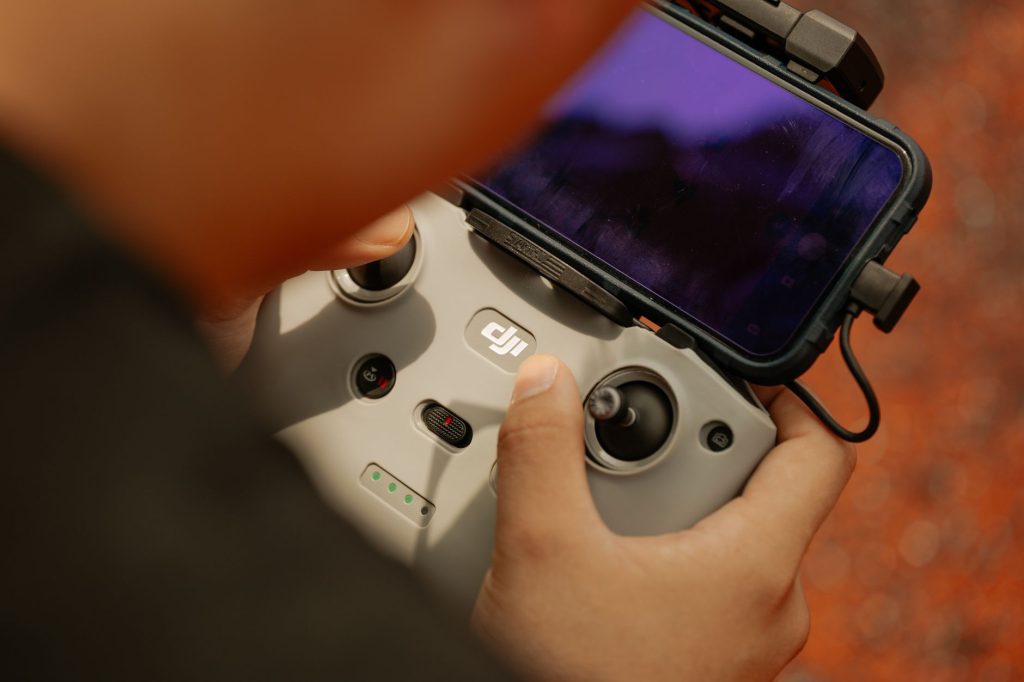 Hands using a modern drone controller with attached smartphone for scenic aerial views. — Functionality and the need to use I