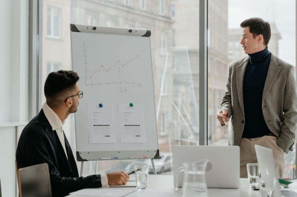 Professionals discussing a business chart in a modern office. — Get Free and Instant Instagram Likes To Increase Your Popular