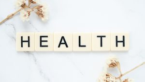 Creative arrangement of scrabble tiles spelling 'Health' with white flowers on a marble surface. — How Do I Get TRT? Complete