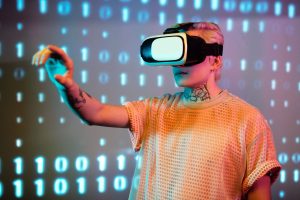 A person experiences virtual reality with a headset against a background of binary code. — How the FinTech Industry Can Benef