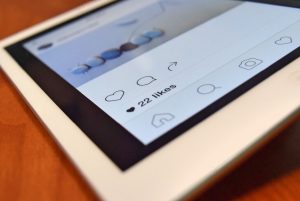 Photo of a tablet displaying a social media app interface with 22 likes, highlighting digital interaction. — Is Buying The In