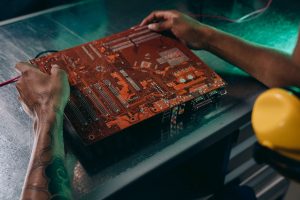 Close-up of a technician working on a circuit board in an industrial setting. — Provide expert assistance for web hosting wit