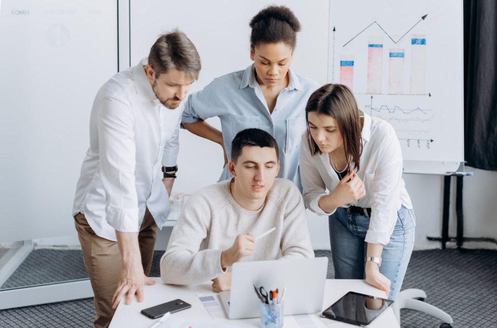 Group of professionals collaborating on a project with graphs in an office setting. — Search engine optimization Services