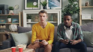 Two friends focus on gaming while relaxing on a couch in a modern living room. — Cash in On the Excitement of No Depo