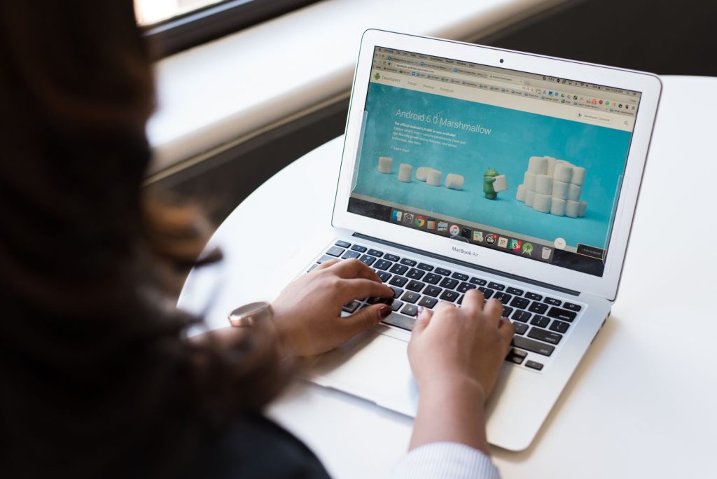 Businesswoman working on laptop with Android 6.0 Marshmallow webpage open. — Transferring Becomes Convenient With The Help Of
