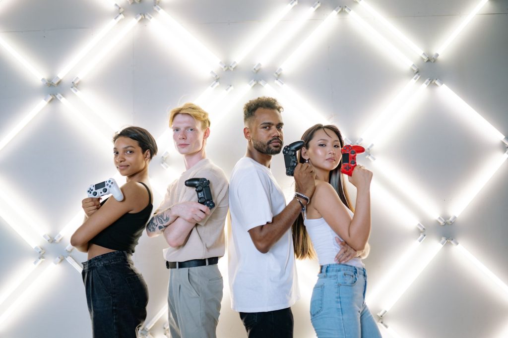 Four diverse friends posing confidently with game controllers against a modern LED backdrop. — Unlimited Lottery Betting with