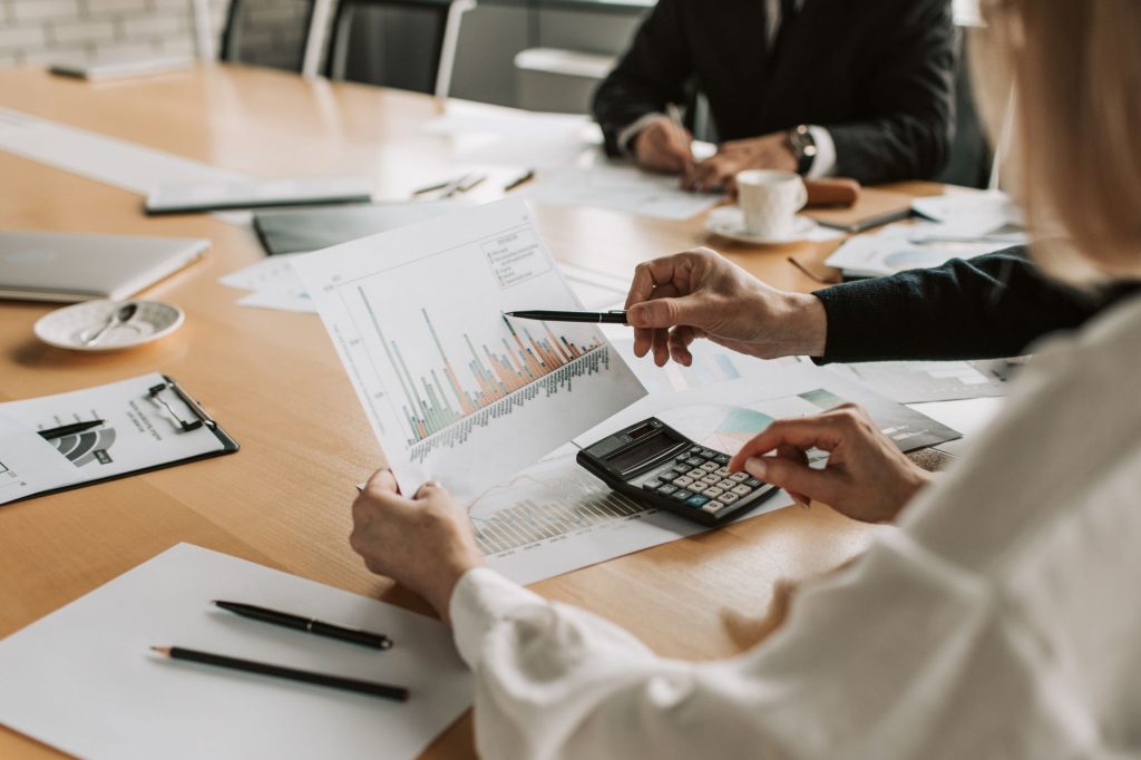 Professionals reviewing financial graphs and charts during a meeting. — Unlocking Organizational Excellence: The Transformati