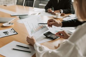 Professionals reviewing financial graphs and charts during a meeting. — Unlocking Organizational Excellence: The Transformati