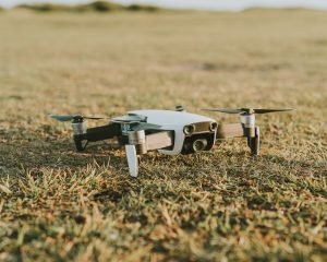 A compact drone rests on a grass field, showcasing technology in a natural setting. — Use Of Bitcoin Loophole And The Feature
