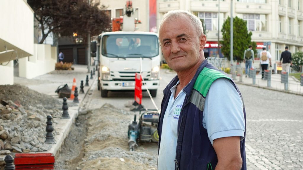 Smiling construction worker on a city street with vehicles and buildings. — Why is it important to store your past memories?