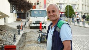 Smiling construction worker on a city street with vehicles and buildings. — Why is it important to store your past memories?